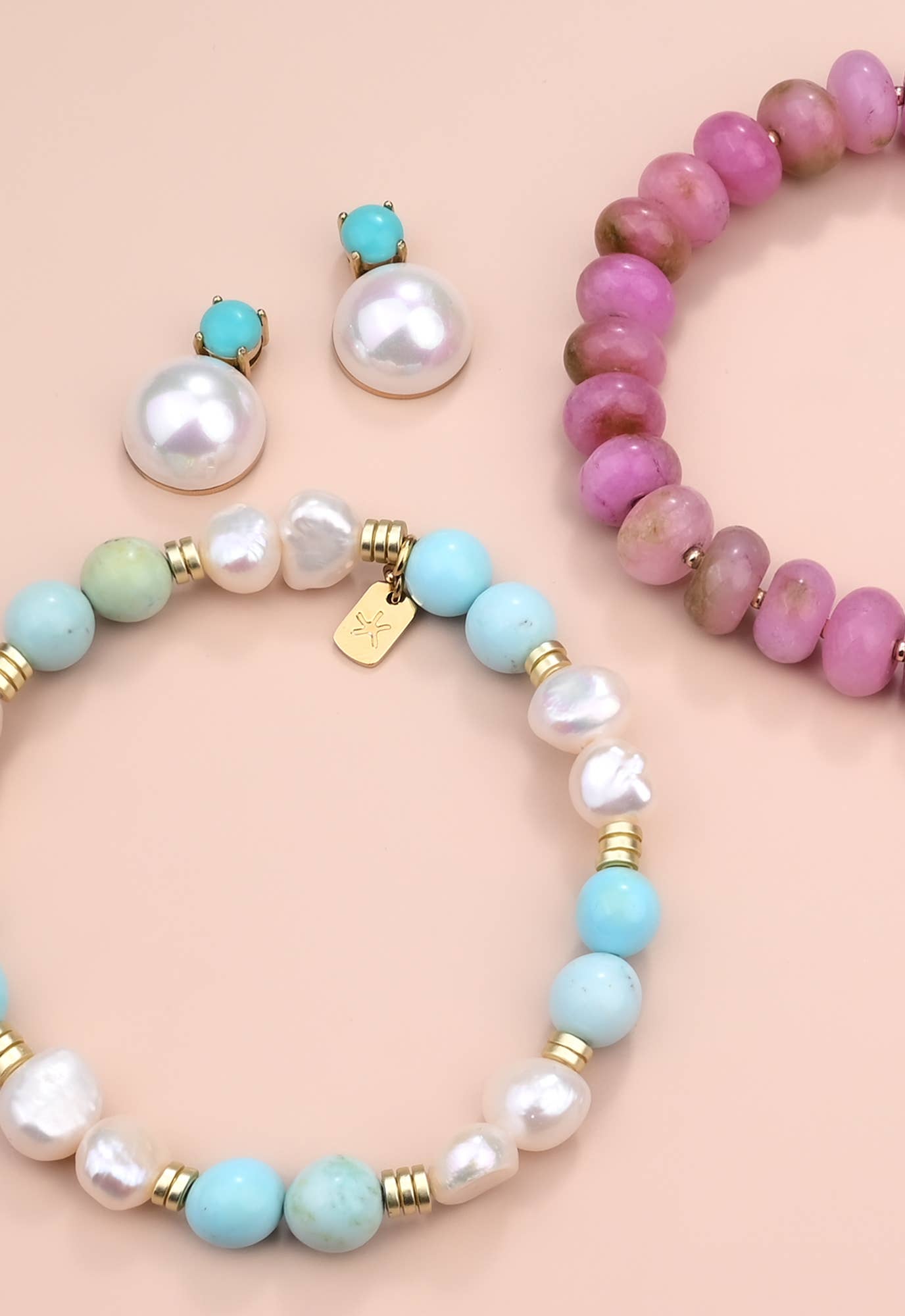 Set of colorful beaded bracelets with pearls on a beige background