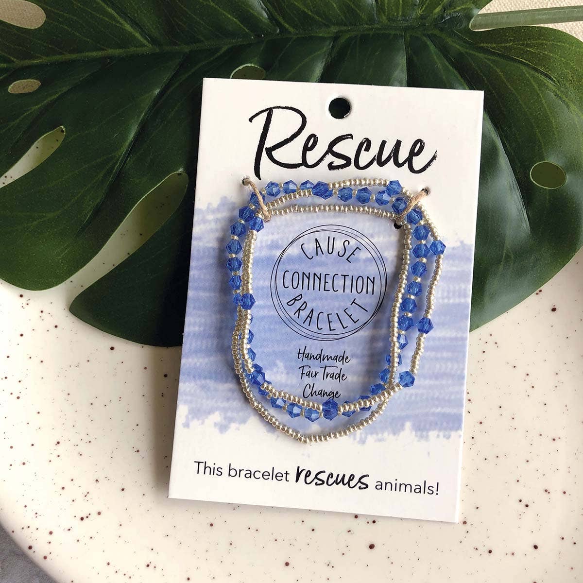 Bracelet on a 'Rescue' branded card with green leaves in the background
