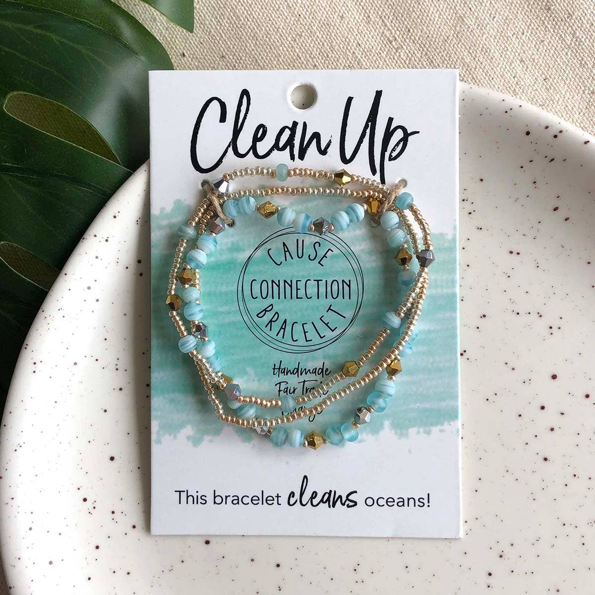 Close-up of blue and gold Clean Up Cause Connection handmade beaded bracelet, a fair trade piece that helps clean oceans.